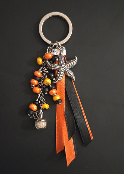 Porte-clés rubans orange et noir avec sable de plage