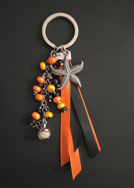 Porte-clés rubans orange et noir avec sable de plage