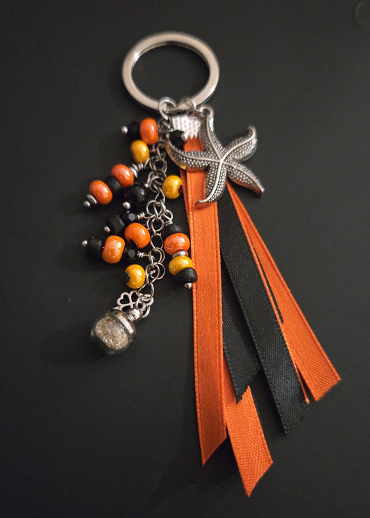 Porte-clés rubans orange et noir avec sable de plage